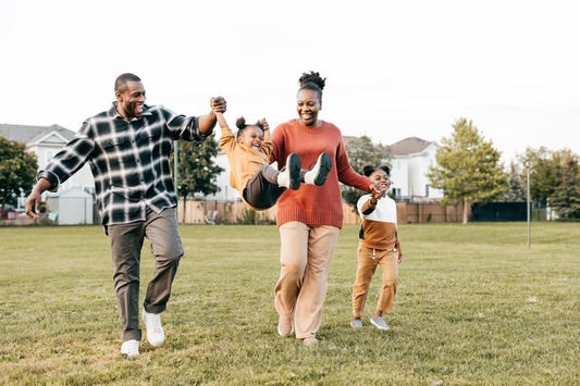 Energetic parents play with children outside