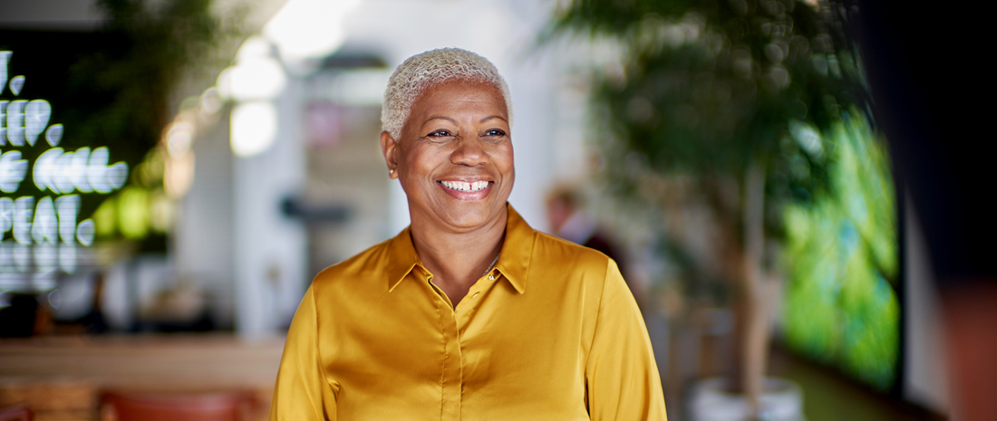 Happy older woman in a bright yellow shirt, smiling