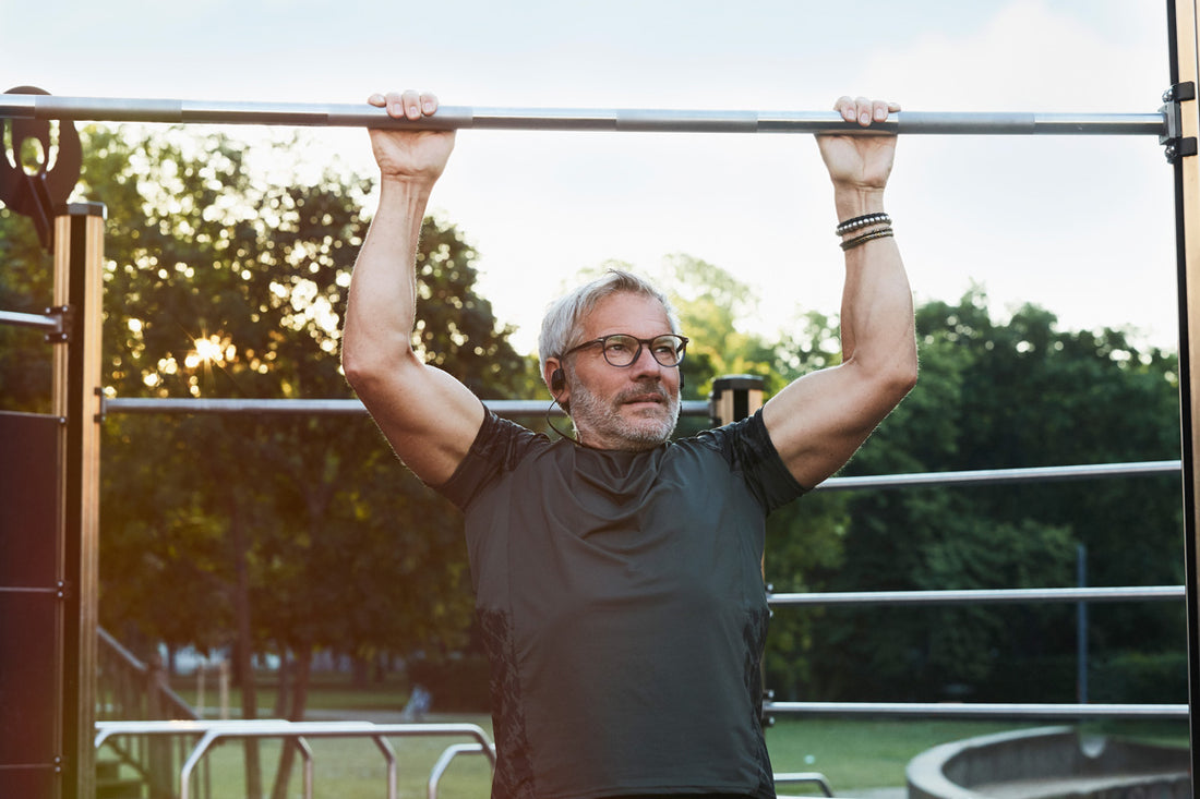 Older man with grey hair works out at the park