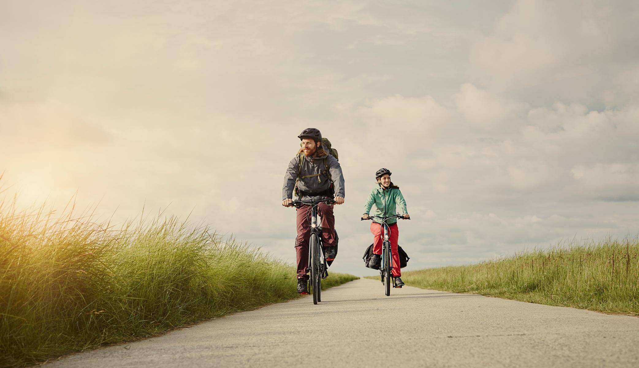 Two adults riding bicycle on a path